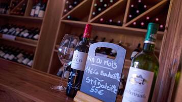A wine bottle with a label, a wine glass, and a chalkboard sign with text.