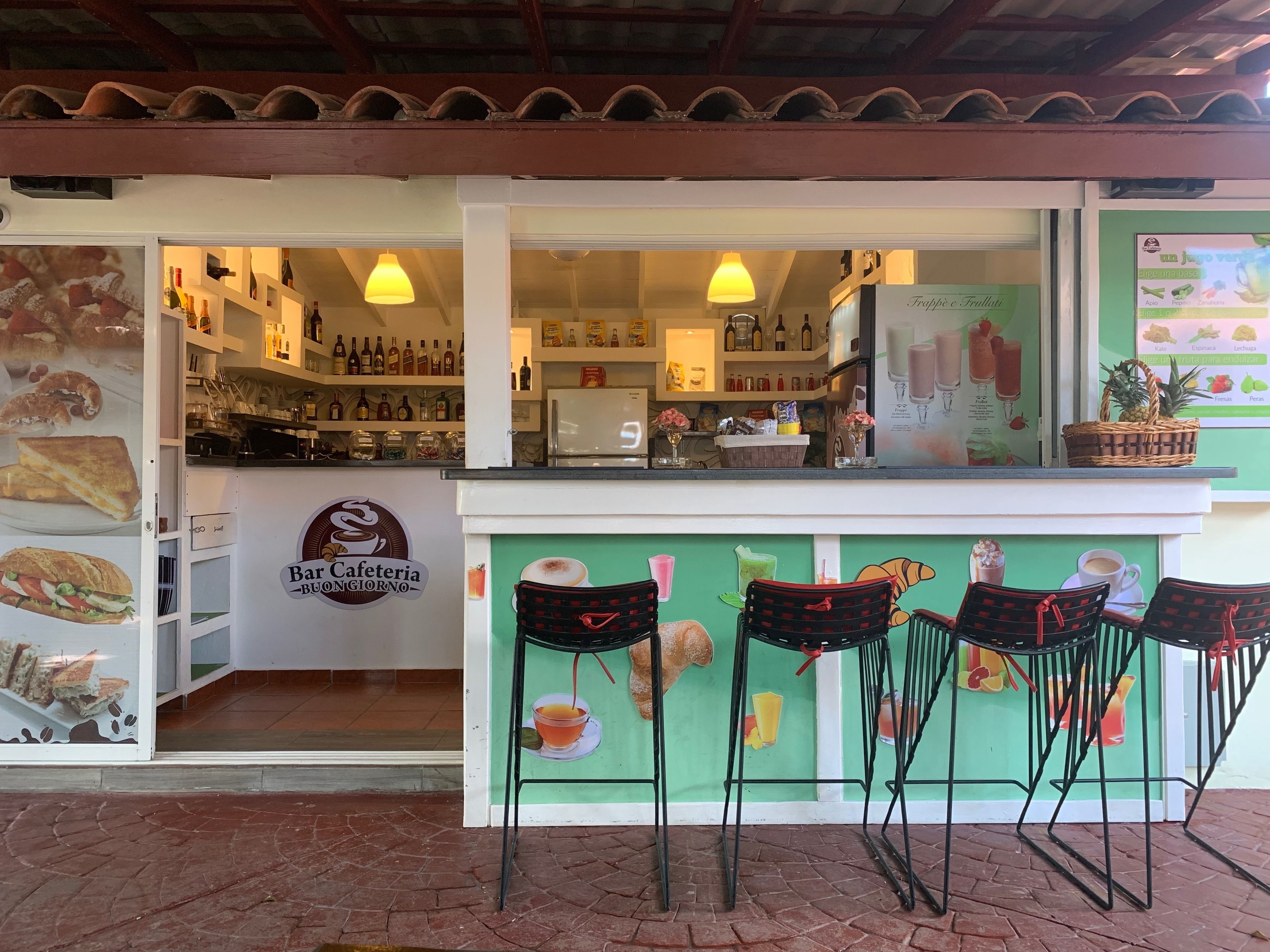 A cafe with a green counter, a sign reading "Bar Cafeteria Bongiorno," and a menu board.