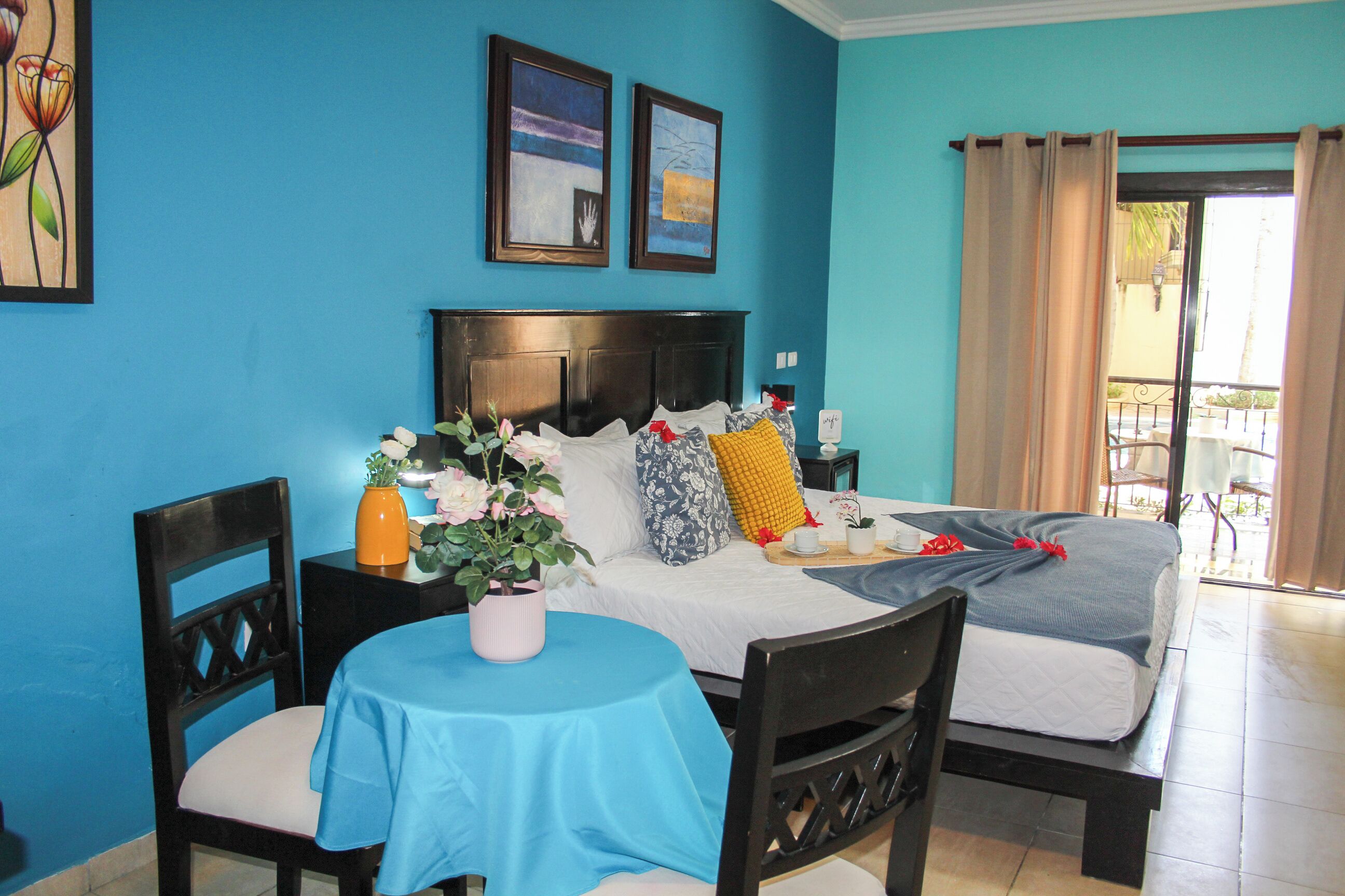 Une chambre d’hôtel avec un lit, une table recouverte d’une nappe bleue et une chaise.