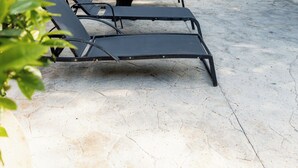 A poolside area with lounge chairs and palm trees. - The MT Hotel (Punta Cana)
