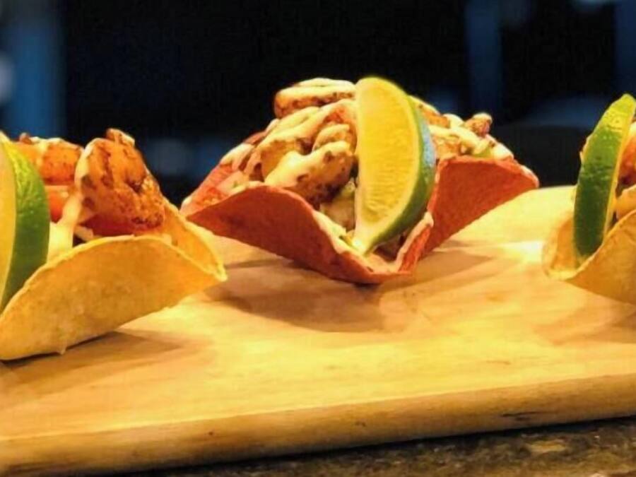 Tres tacos sobre una tabla de madera.