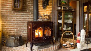 Un horno de leña tradicional, un reloj y una decoración rústica con un peluche.