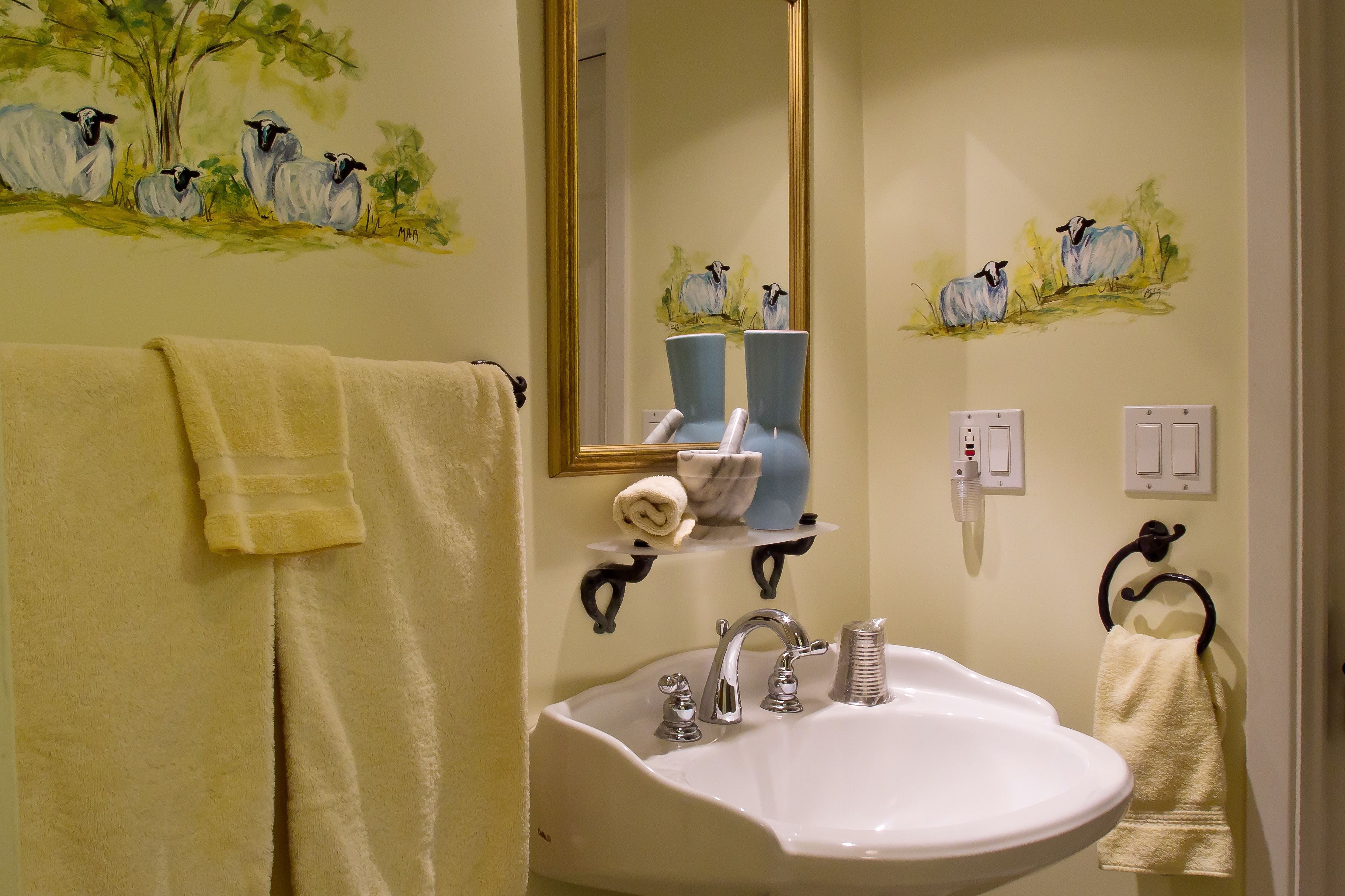 A bathroom with a sink, mirror, and towels.