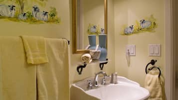 A bathroom with a sink, mirror, and towels.