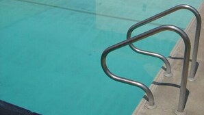 Une piscine aux eaux cristallines, avec une échelle métallique qui y mène.