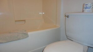 Une salle de bain avec une baignoire, des toilettes et un porte-serviettes.