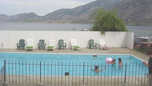 A swimming pool with a view of mountains and a lake. - Falcon Resort (Osoyoos)