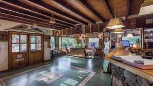 A spacious lobby with wooden beams, a stone counter, and a large window offering a view of the outdoors.