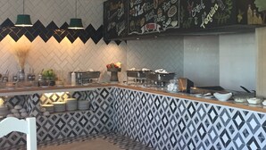 A modern kitchen with a chalkboard menu listing various food items and drinks. - Hotel Estancia Business Class (Guadalajara)