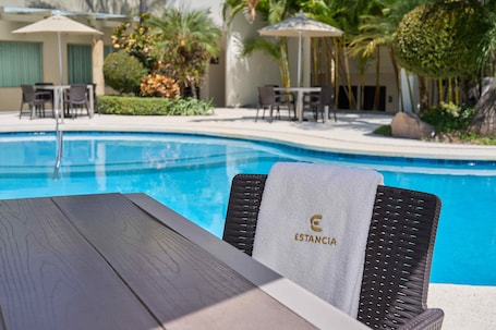 Outdoor pool, open 9 AM to 9 PM, pool umbrellas, pool loungers. Hotel Estancia Business Class