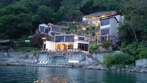 A modern coastal property with multiple levels, a stone staircase, and a pool area. - Hotel La Villa de los Dioses (San Antonio Palopo)