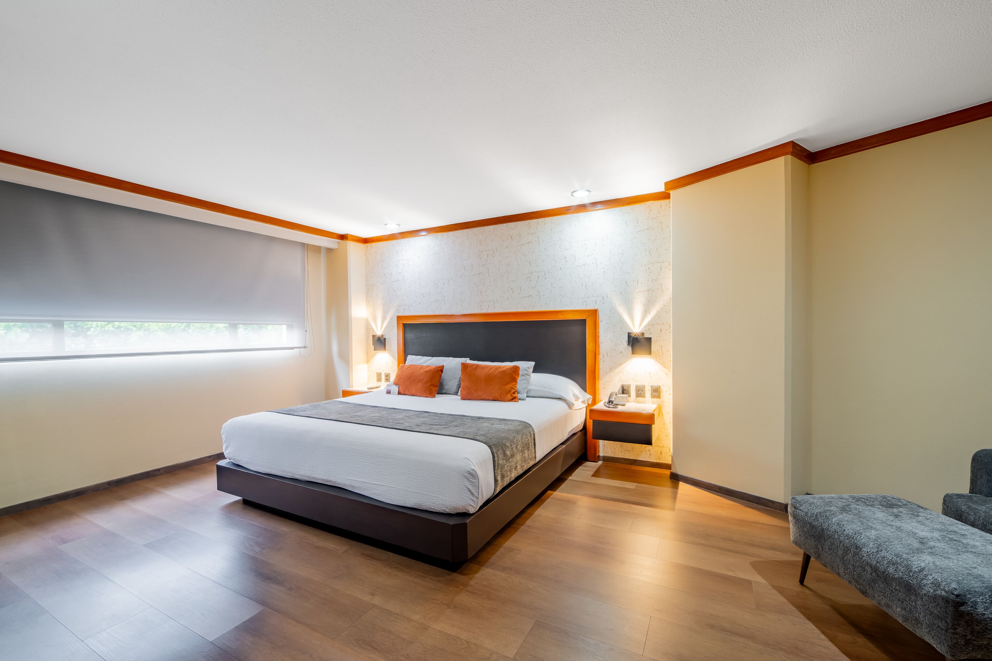 Ein modernes Schlafzimmer mit einem großen Bett, Nachttischlampen und Blick ins Freie.