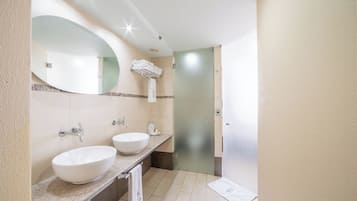 Casa de banho com duas pias, um espelho grande e um porta-toalhas.