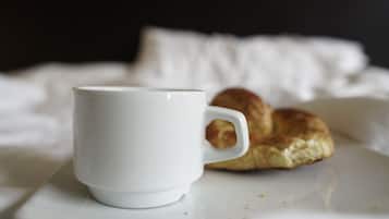 A white cup and a pastry on a white plate.