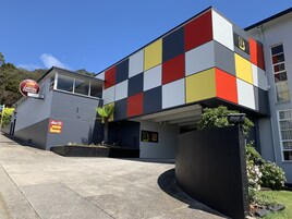 Un edificio moderno con fachada colorida, un cartel de estacionamiento y un letrero de hotel.