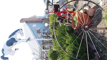Un manège avec une figure de cheval, une grande roue et un bâtiment avec un toit bleu en arrière-plan.