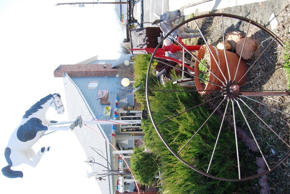 A carousel with a horse figure, a large wheel, and a building with a blue roof in the background. - Redwood Motel (Bridgeport)