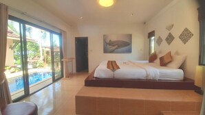 A spacious bedroom with a large bed, a view of a swimming pool, and a wall with a shark painting. - Samui Diving Resort (Koh Samui)