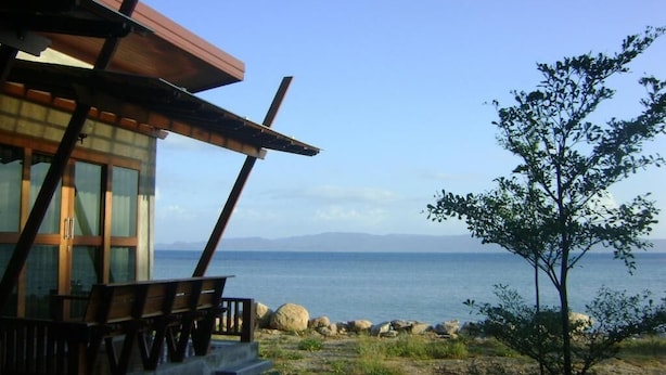 Un edificio con terraza de madera y vista al mar.
