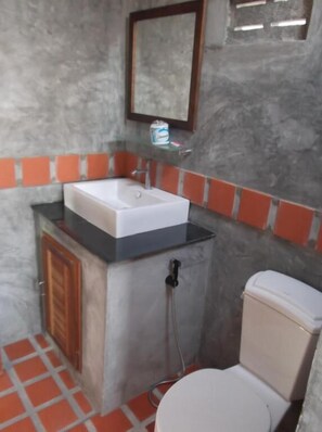 A compact bathroom with a white sink, a toilet, and a shower area. - Phangan Palm Beach Resort (Ko Pha-ngan)