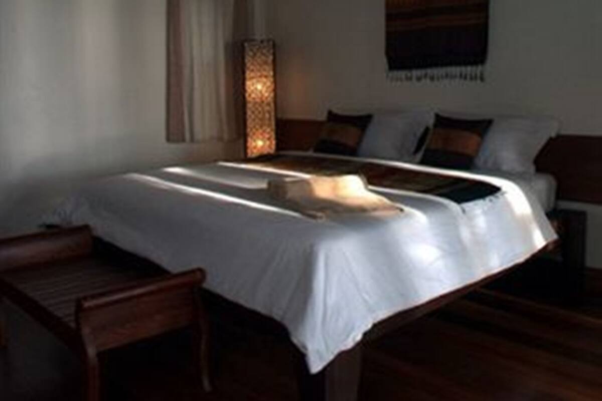 Un dormitorio con una cama, una mesita de noche y una lámpara.
