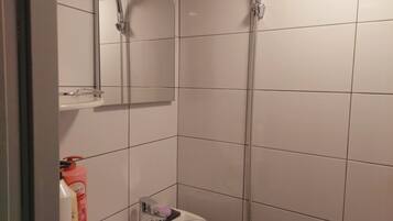A bathroom with a shower, a sink, and a mirror.
