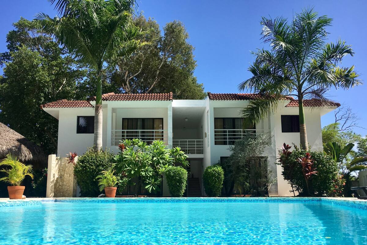 Un edificio de dos pisos con una piscina al frente.