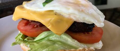A sandwich with lettuce, tomato, egg, and cheese on a bun.