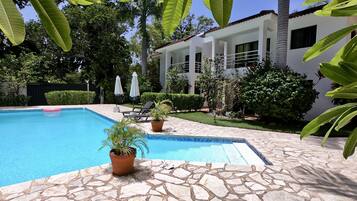 Una piscina al aire libre, sombrillas, tumbonas