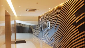 A modern interior with a curved wall design, a reception area, and a clear pathway leading to a seating area.