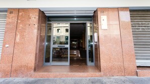 A building entrance with a glass door, numbered 21 and 25, leading to a staircase. - Trastevere's Friends (Rome)