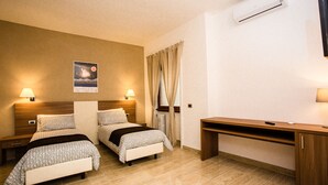 A hotel room with two beds, a desk, and a nightstand. - Trastevere's Friends (Rome)
