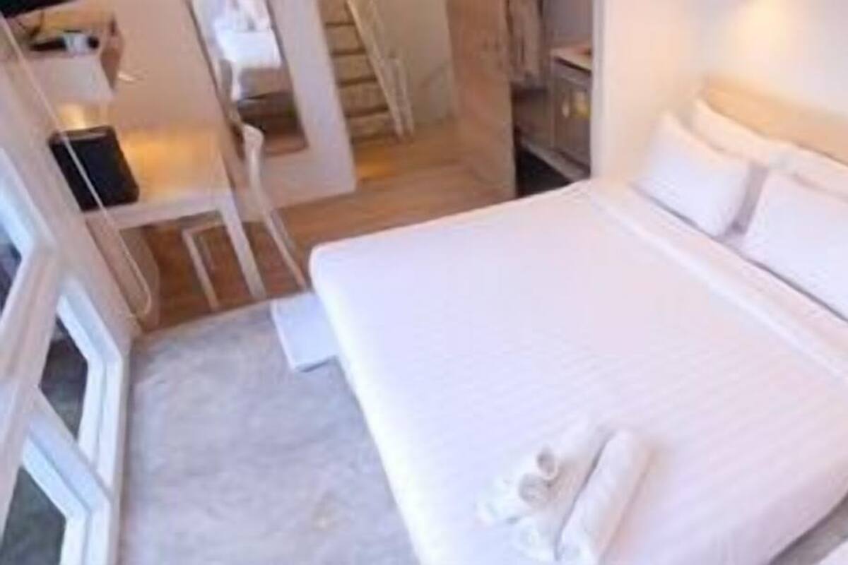 Een hotelkamer met een groot bed, een nachtkastje en een stoel.