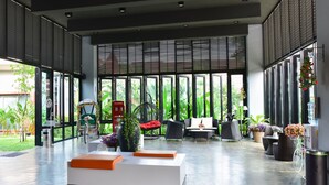 A spacious indoor area with large windows, modern furniture, and a variety of plants. - Milano Hua Hin (Hua Hin)