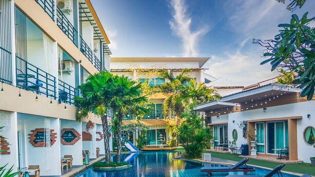 A modern hotel with a swimming pool, outdoor seating, and a covered patio area. - Milano Hua Hin (Hua Hin)