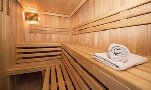 Un sauna en bois avec des bancs et un banc muni d’une serviette.