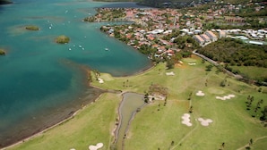 An aerial view of a coastal golf course with a residential area nearby. - Résidence Bel'Bay (Les Anses-d'Arlets)