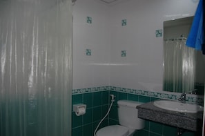 A bathroom with a toilet, sink, and mirror.