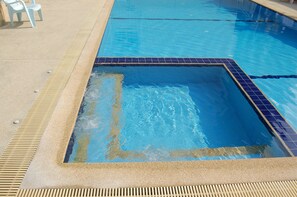 A rectangular pool with a tiled border and a drain channel on one side. - Baan Manthana House (Hua Hin)