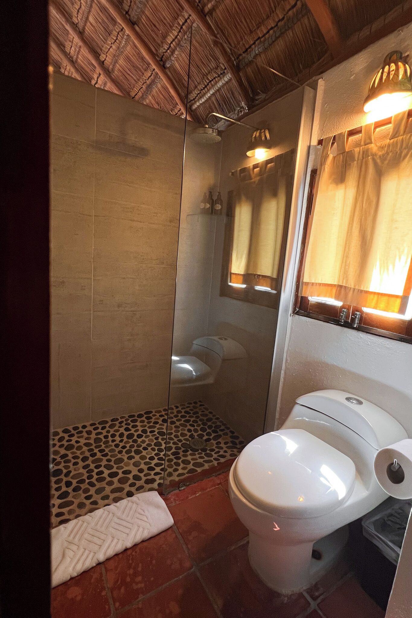 A bathroom with a shower, toilet, and a mirror.