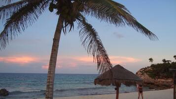 Playa privada, arena blanca, sillas reclinables de playa, sombrillas