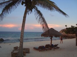 Playa privada, arena blanca, sillas reclinables de playa, sombrillas