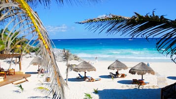 Playa privada, arena blanca, sillas reclinables de playa, sombrillas