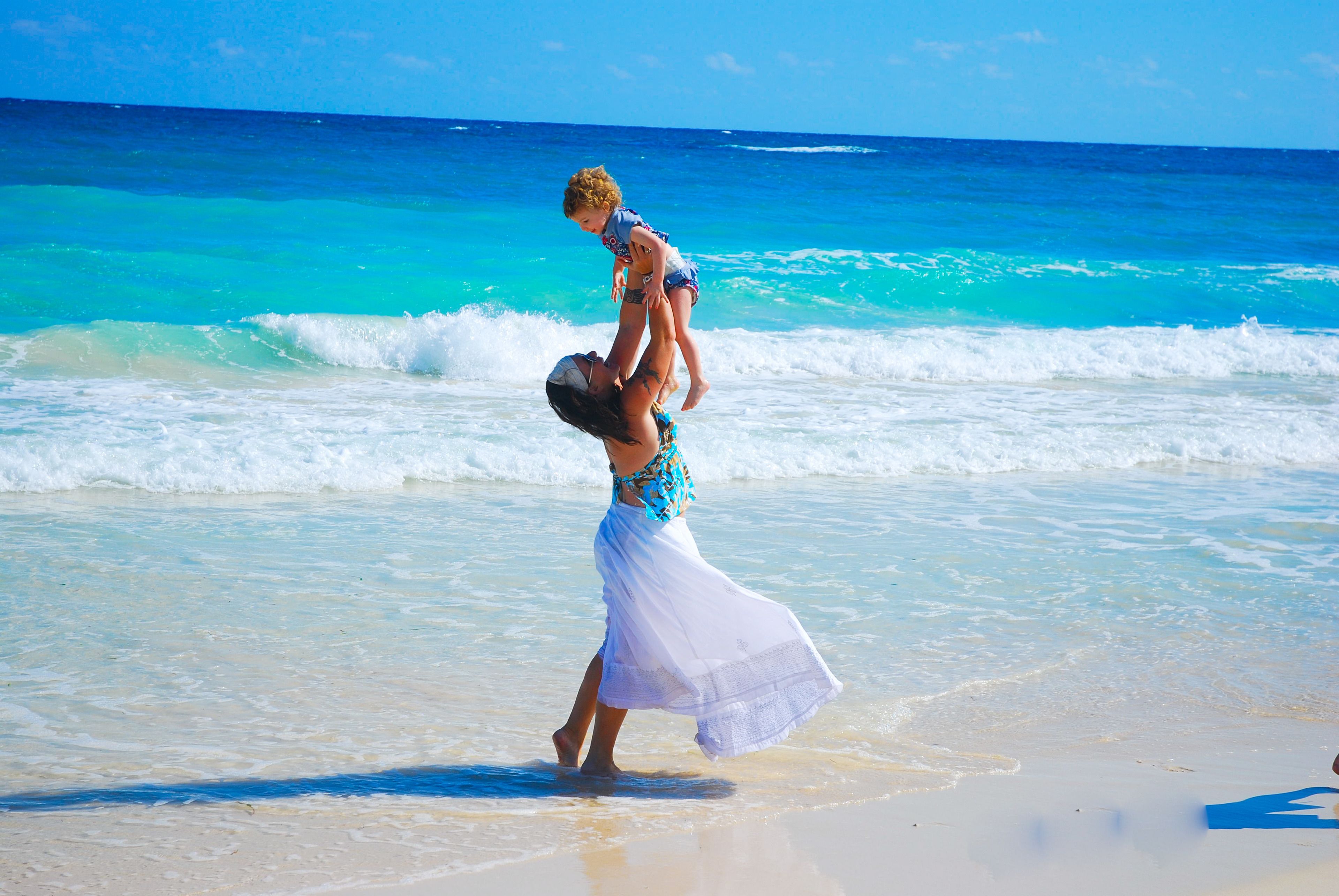 A beach scene with clear turquoise waters and a sandy shore.