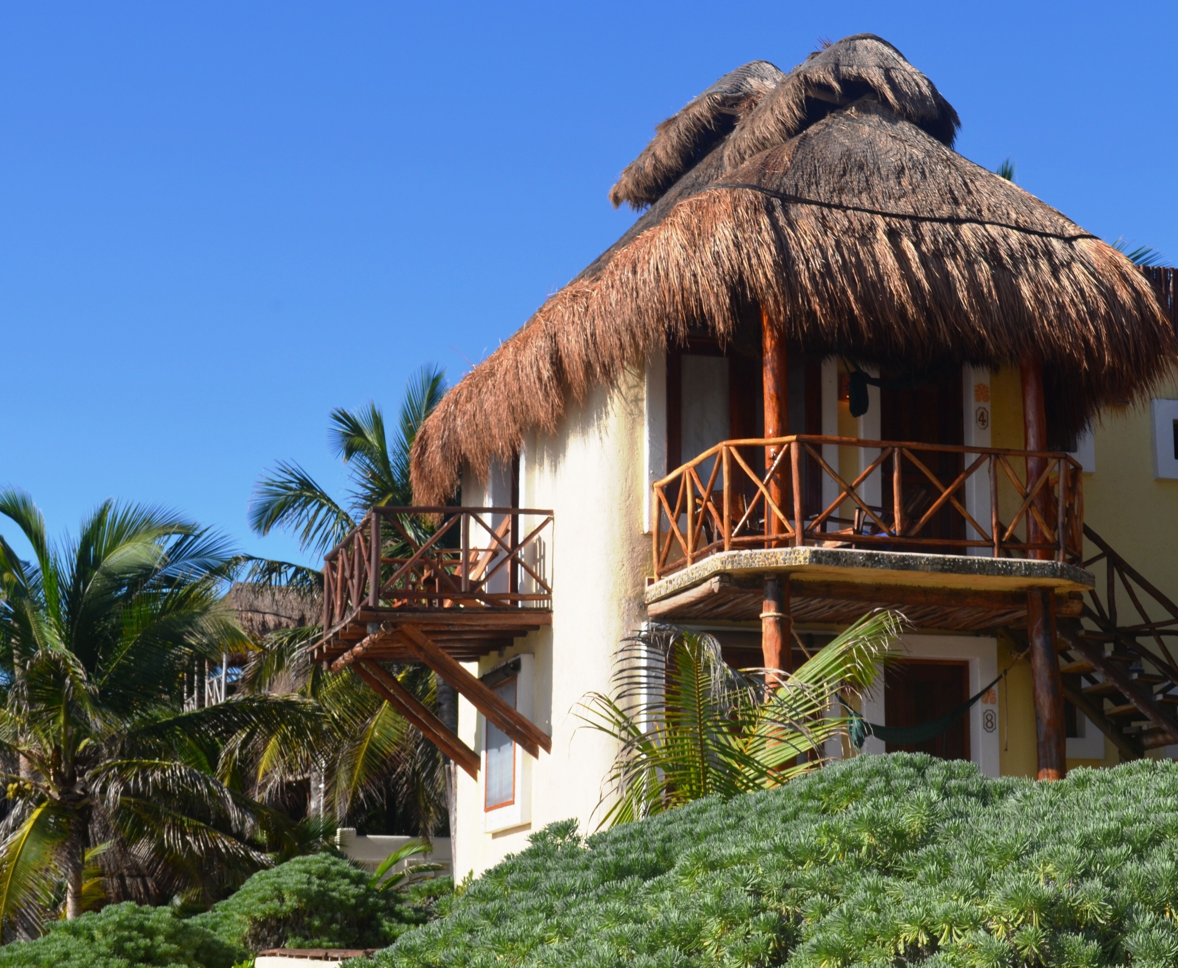 A two-story building with a thatched roof and wooden balcony railings.