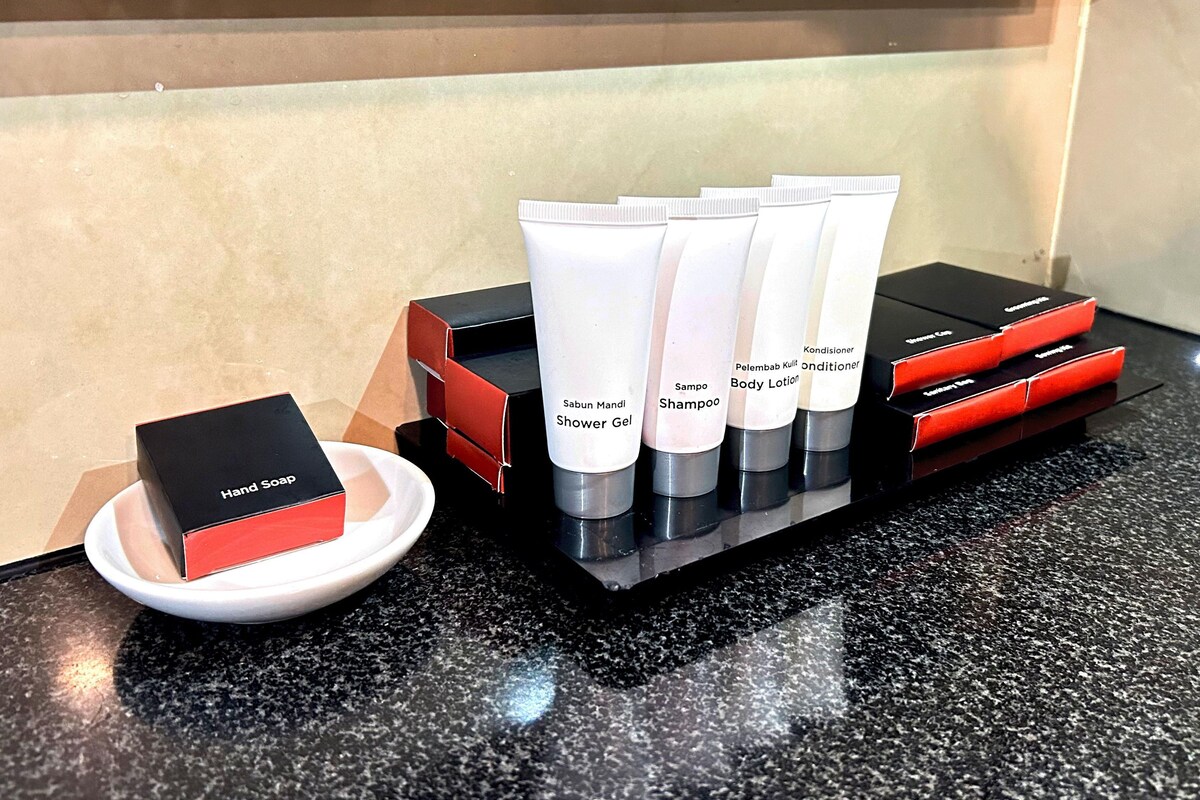 A display of toiletries including hand soap, shower gel, shampoo, body lotion, and conditioner.
