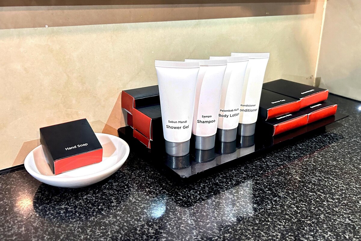 A display of toiletries including hand soap, shower gel, shampoo, body lotion, and conditioner.