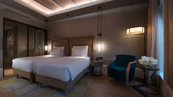 Une chambre d’hôtel avec deux lits, un bureau, une chaise et une fenêtre avec des rideaux.