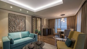 A modern living room with a sofa, a coffee table, and a dining area with chairs and a table. - 10 Karakoy Istanbul - Special Class (Istanbul)