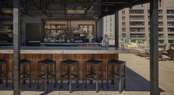 Een buitengebied met een bar, krukken en verschillende flessen.